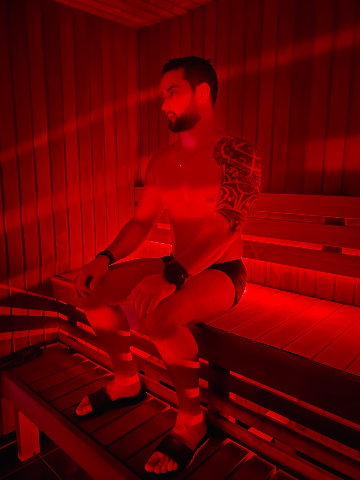 Man relaxing in an infrared sauna with red light therapy
