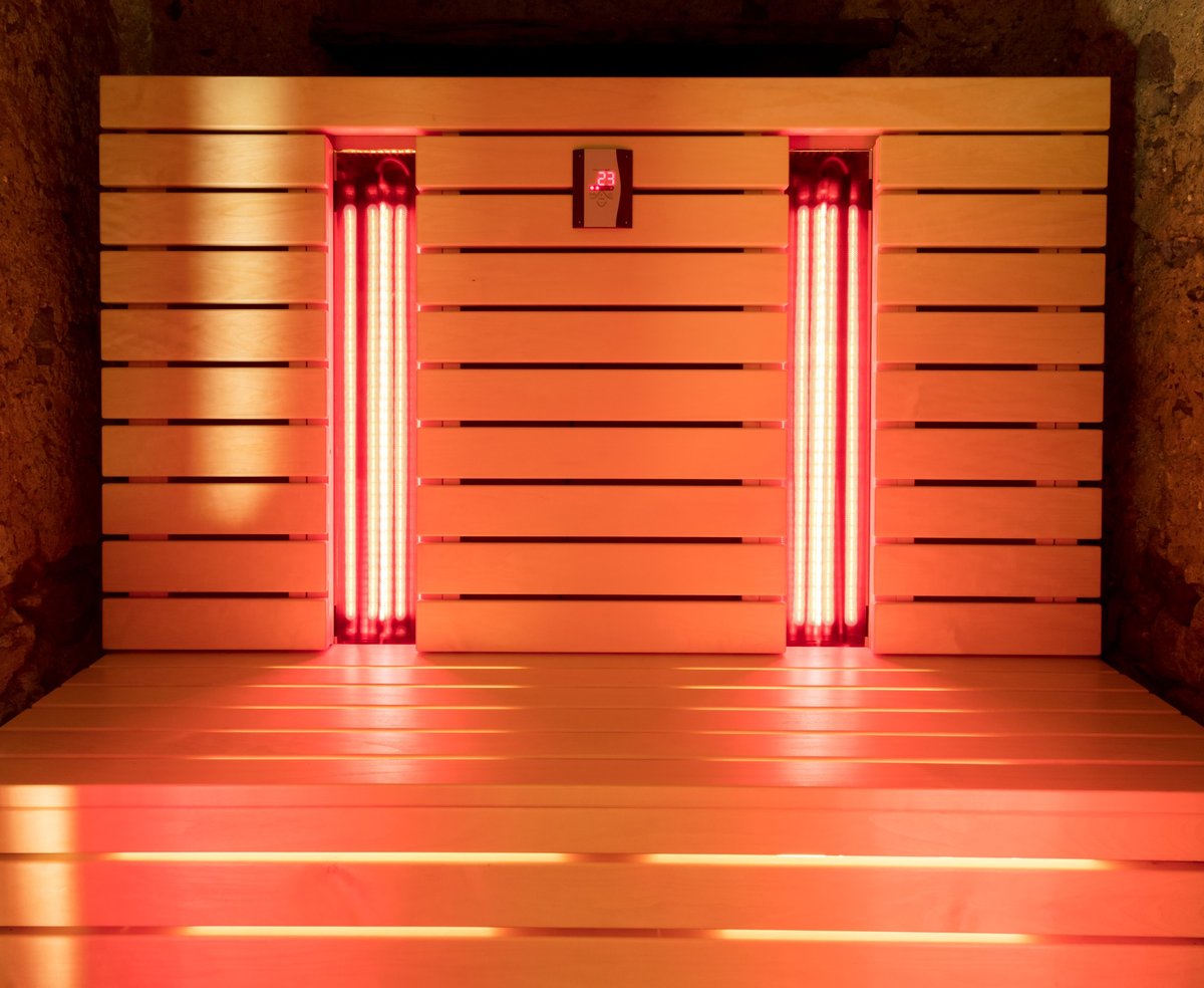 Infrared sauna panels glowing in a wood-lined cabin